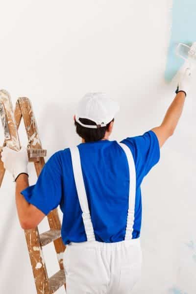 man painting inside house